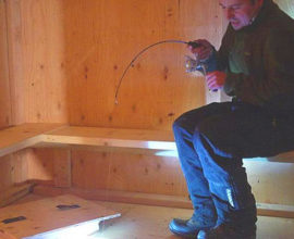 Things to do near Fairbanks - Image of person Ice Fishing in a hut