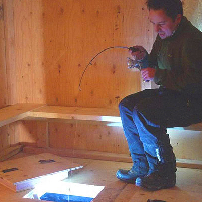 Things to do near Fairbanks - Image of person Ice Fishing in a hut